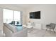 Living room with gray sofa, large TV, and balcony access at 3151 Paradox Cir # 405, Kissimmee, FL 34746