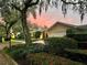 Inviting home exterior at dusk, showcasing landscaping and brick driveway at 370 E Lake Sue Ave, Winter Park, FL 32789