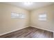 Bright bedroom featuring wood-look floors and two windows at 5219 Montague Pl, Orlando, FL 32808