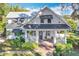 Charming two-story home featuring a cozy front porch, manicured landscaping, and classic architectural details at 527 Broadway Ave, Orlando, FL 32803