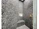 Walk-in shower with pebble stone tile and built-in seat at 527 Broadway Ave, Orlando, FL 32803