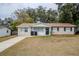 Tan house with a brown roof, driveway, and small front yard at 5511 Indian Hill Rd, Orlando, FL 32808