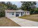Tan house with brown roof and a driveway at 5511 Indian Hill Rd, Orlando, FL 32808