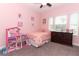 Charming pink bedroom featuring a cozy bed, dollhouse, and ample natural light at 618 Windy Pine Way, Oviedo, FL 32765