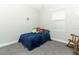 Cozy bedroom with plush blue bedding, soft gray carpeting, and a vintage rocking chair at 618 Windy Pine Way, Oviedo, FL 32765