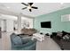 Relaxing living room with teal accent wall, comfy sofas, and a large flat-screen TV at 618 Windy Pine Way, Oviedo, FL 32765