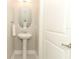 Stylish powder room with a pedestal sink, decorative mirror, and modern fixtures at 618 Windy Pine Way, Oviedo, FL 32765