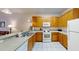 Kitchen with wood cabinets, white appliances, and granite countertops at 702 Rum Run # 38702, Davenport, FL 33897