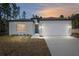 New construction home with white exterior, two-car garage, and landscaping at 8549 Sw 129Th Ln, Ocala, FL 34473