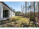 Side view of a house showcasing a covered patio and grassy yard at 8549 Sw 129Th Ln, Ocala, FL 34473