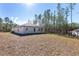 View of house exterior showcasing backyard and surrounding pine trees at 8549 Sw 129Th Ln, Ocala, FL 34473