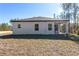 Rear view of a single-story house with covered patio and grassy backyard at 8549 Sw 129Th Ln, Ocala, FL 34473