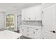 White shaker kitchen cabinets with gray backsplash and quartz countertops at 8549 Sw 129Th Ln, Ocala, FL 34473