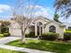 Inviting single-story home with manicured lawn, mature tree, and attached two-car garage at 943 Oak Chase Dr, Orlando, FL 32828