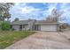 Gray house with white garage door, landscaping, and driveway at 964 Sand Crest Dr, Port Orange, FL 32127