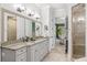 Spa-like bathroom featuring double sinks, a large shower, and views into the bedroom at 1000 Via Tuscany Oaks Way, Winter Park, FL 32789