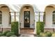 Elegant entryway with arched details and a dark door at 1000 Via Tuscany Oaks Way, Winter Park, FL 32789