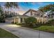 Two-story house with a balcony, arched entryway, and manicured lawn at 1000 Via Tuscany Oaks Way, Winter Park, FL 32789