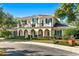 Two-story house with a balcony, arched entryway, and manicured lawn at 1000 Via Tuscany Oaks Way, Winter Park, FL 32789