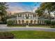 Two-story house with a balcony, arched entryway, and manicured lawn at 1000 Via Tuscany Oaks Way, Winter Park, FL 32789