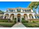 Two-story house with a balcony, arched entryway, and manicured lawn at 1000 Via Tuscany Oaks Way, Winter Park, FL 32789