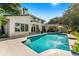 Beautiful home exterior with a large pool and lush landscaping at 1000 Via Tuscany Oaks Way, Winter Park, FL 32789