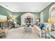 Living room with green walls, stylish furnishings, and a view into the dining room at 1000 Via Tuscany Oaks Way, Winter Park, FL 32789