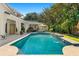 Stunning pool and patio area with outdoor kitchen and lounge seating at 1000 Via Tuscany Oaks Way, Winter Park, FL 32789