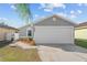 Gray house with a white garage door and landscaping at 1058 Florida Holly Dr, Orlando, FL 32811