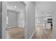 Hallway view of a bedroom and kitchen with light gray walls and wood flooring at 1058 Florida Holly Dr, Orlando, FL 32811