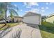 House exterior with a white garage door and landscaping at 1058 Florida Holly Dr, Orlando, FL 32811