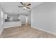 Open living room with kitchen view, light gray walls, and wood flooring at 1058 Florida Holly Dr, Orlando, FL 32811