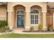 House entrance with blue door, arched entryway, and potted plants at 11537 Blackmoor Dr, Orlando, FL 32837