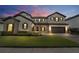 Two-story house with stone accents and a three-car garage at dusk at 11769 Hampstead St, Windermere, FL 34786