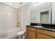 This bathroom features a shower-tub combo and dark wood vanity at 14190 Dove Hollow Dr, Orlando, FL 32824