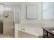 Bathroom with a soaking tub, glass-enclosed shower, and tiled walls at 14190 Dove Hollow Dr, Orlando, FL 32824