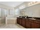 Luxurious bathroom with a soaking tub, glass-enclosed shower, and dual vanities at 14190 Dove Hollow Dr, Orlando, FL 32824