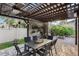 An outdoor dining area with stone wall, wood pergola with ceiling fans, a table, chairs, and fire pit at 14190 Dove Hollow Dr, Orlando, FL 32824