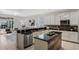 Modern kitchen with island, white cabinetry, black countertops, stainless steel appliances, and breakfast bar at 14190 Dove Hollow Dr, Orlando, FL 32824