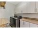 This laundry room features a washer and dryer, with overhead cabinets at 14190 Dove Hollow Dr, Orlando, FL 32824