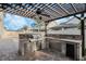 Outdoor kitchen with stainless steel grill, beverage fridge, sink, storage and granite countertops at 14190 Dove Hollow Dr, Orlando, FL 32824
