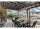 Outdoor dining area featuring a pergola, ceiling fan, stone wall, fire pit, and views of the backyard at 14190 Dove Hollow Dr, Orlando, FL 32824