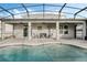 Inviting covered patio with ample seating and a sparkling pool is the perfect spot for relaxing and entertaining at 14190 Dove Hollow Dr, Orlando, FL 32824