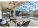 A delightful covered patio overlooks a sparkling pool, an outdoor kitchen, and manicured landscaping at 14190 Dove Hollow Dr, Orlando, FL 32824