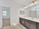 Double vanity bathroom with dark brown cabinets and tiled floor at 144 Trinity Ridge Cir, Davenport, FL 33897