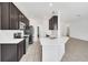 Modern kitchen with dark cabinets, stainless steel appliances, and a large island at 144 Trinity Ridge Cir, Davenport, FL 33897