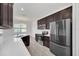 Modern kitchen with dark cabinets and stainless steel appliances at 144 Trinity Ridge Cir, Davenport, FL 33897