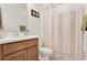 Simple bathroom with beige striped shower curtain and wood vanity at 1593 Osprey View Dr, Apopka, FL 32703