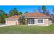 Tan one-story house with brown roof, attached garage, and landscaped yard at 18433 Reynolds Pkwy, Orlando, FL 32833