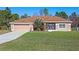 Single-story home with a brown roof, attached garage, and landscaped yard at 18433 Reynolds Pkwy, Orlando, FL 32833